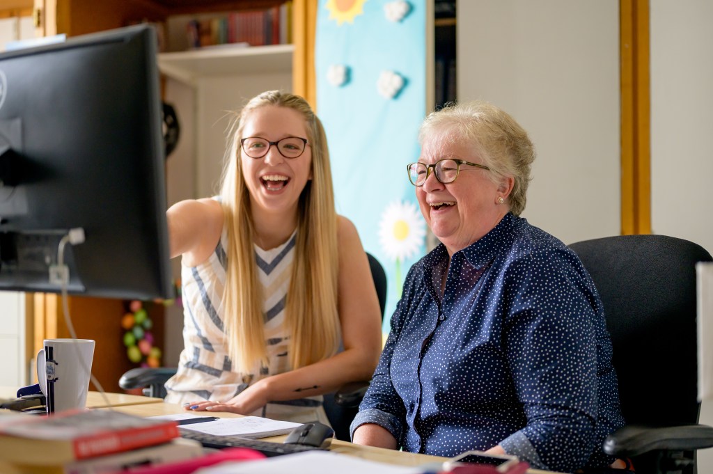 Two women working at a computer.