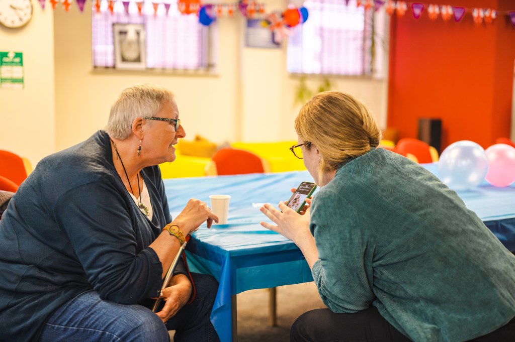 Image of two women looking a mobile phone.
