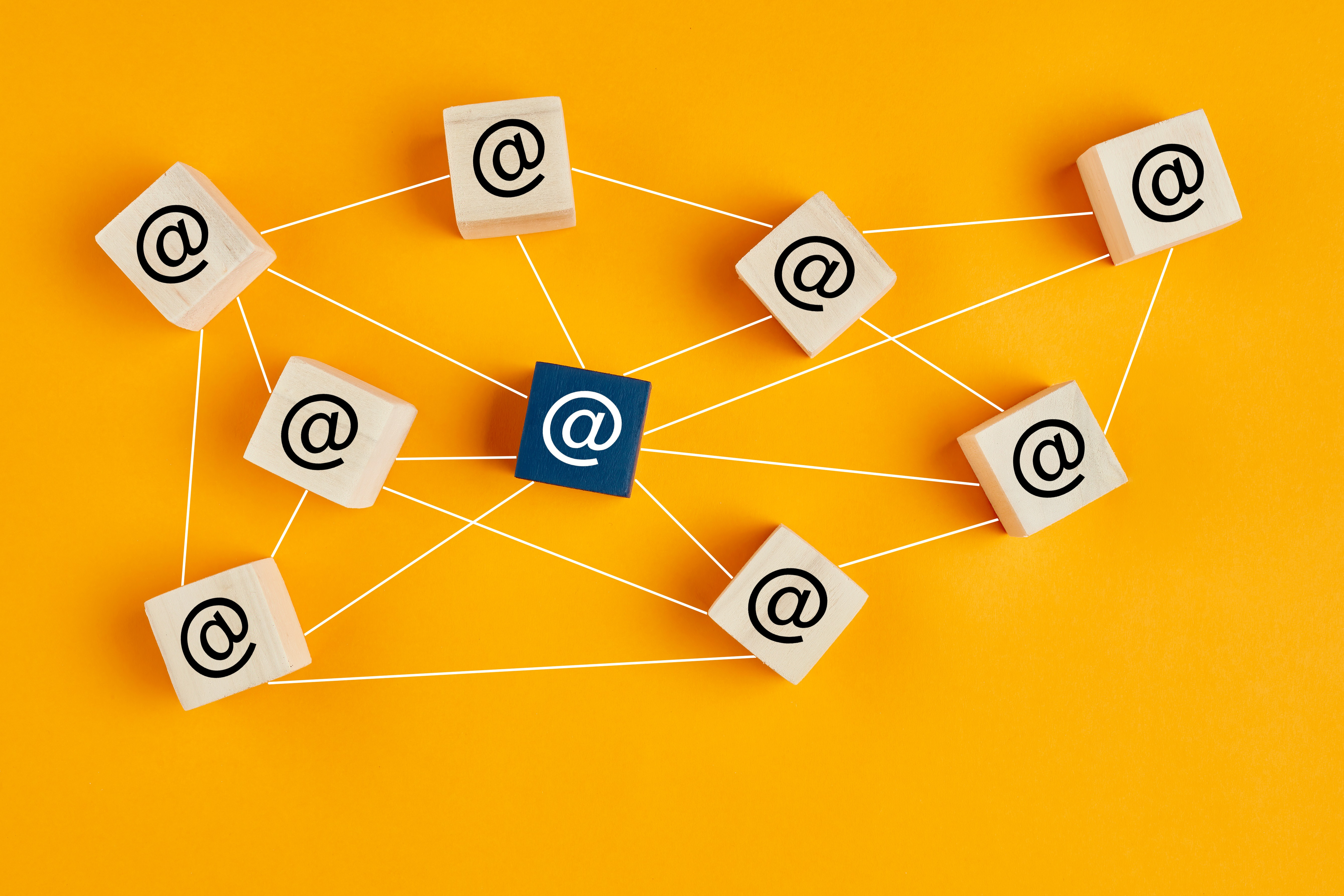 Email at symbol on wooden cubes linked each other with lines.
