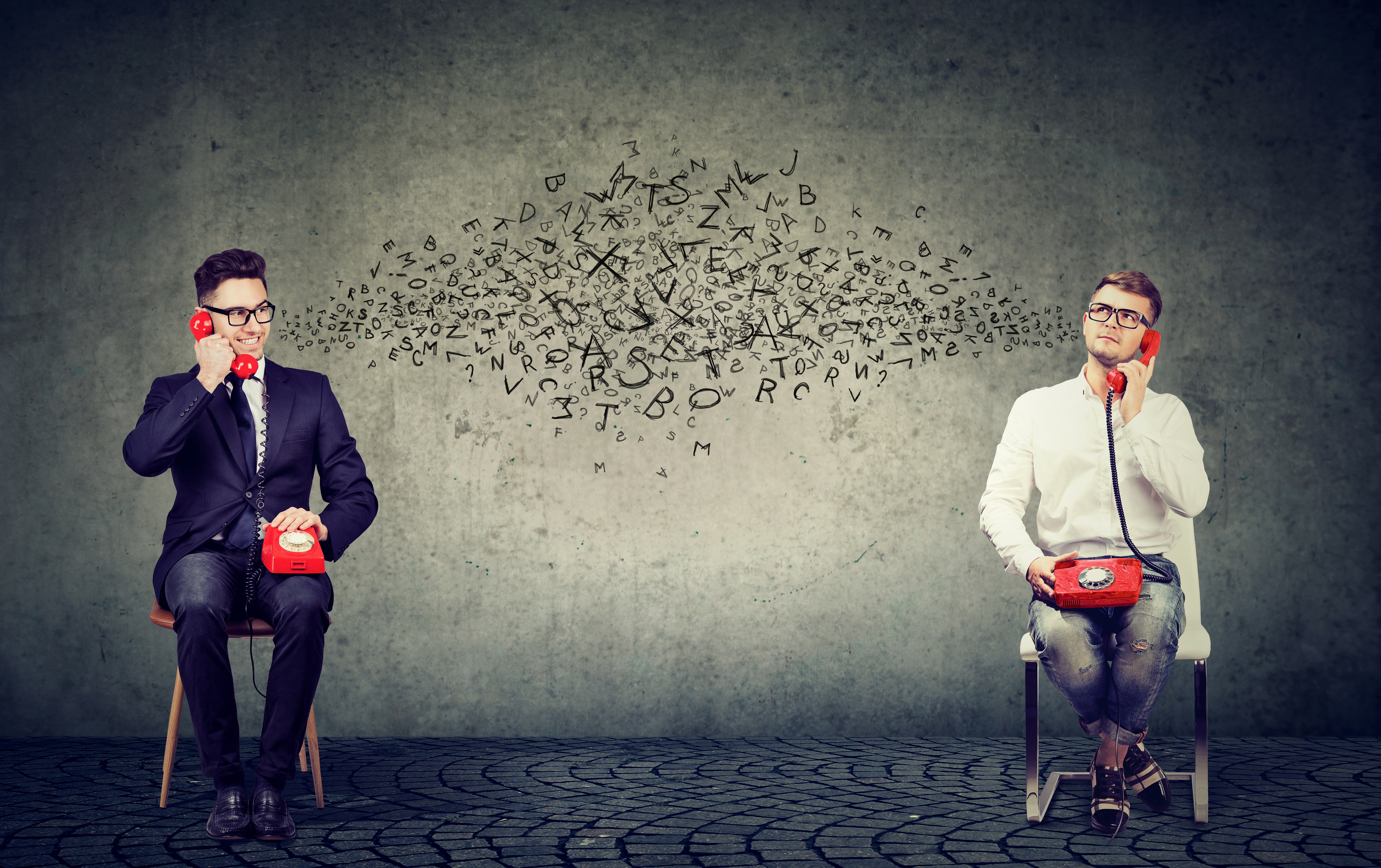 Young men communicating through phone with alphabetic letters flying between on grey background.